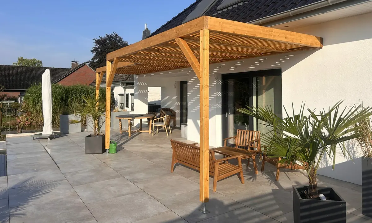Von uns gebaute Terrassenüberdachung aus Holz an einem modernen Wohnhaus